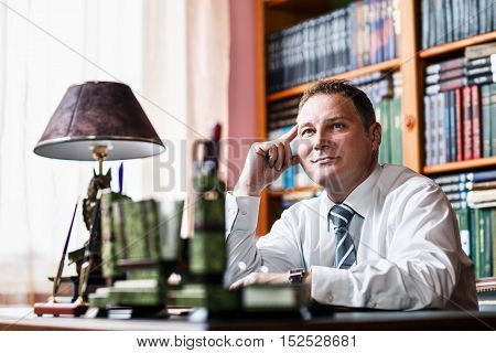 Confident businessman sitting at the tabble in his home office