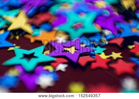 small multi-colored stars on a red background