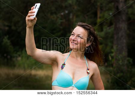 Girl In Bathing Suit In The Forest And Cell Phone