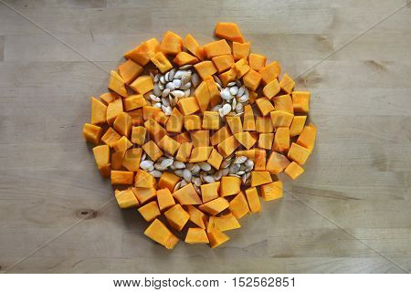 Halloween pumpkin sliced with seeds on a wooden table