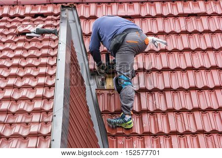 Roofer repair the roof of clay tiles