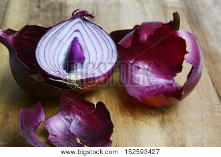 close up from peeled red onion on wooden board