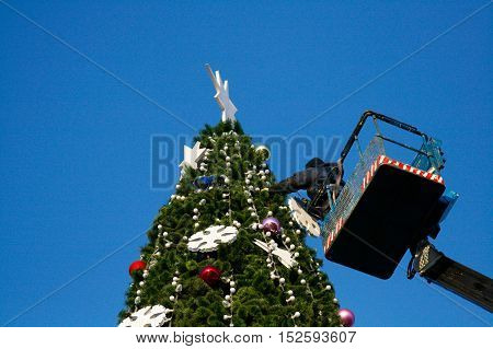 Volgograd Russia - December 20 2008: A worker decorates a Christmas tree