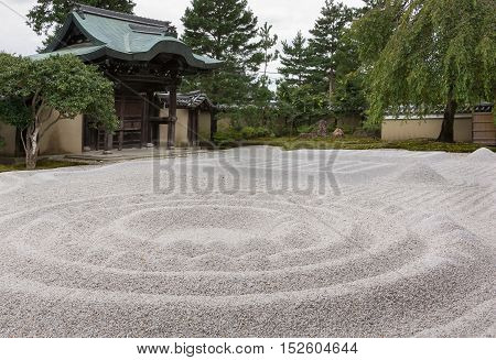 Kyoto Japan - September 19 2016: The famous Zen garden at the Kodai-ji Buddhist Temple sits between the hall and the historic main entrance gate. It consists of beige pebbles raked in geometric figures.