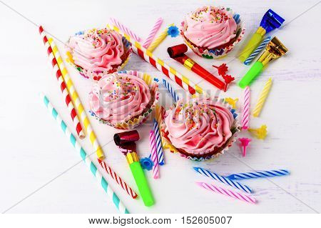 Birthday party concept with decorated pink cupcakes and candles. Homemade cupcakes served for party. Birthday greeting background.
