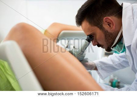 Gynecologist Examining A Patient With A Colposcope