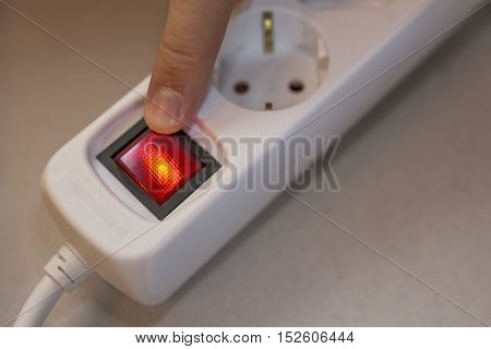 Finger will turn off red button of white socket strip
