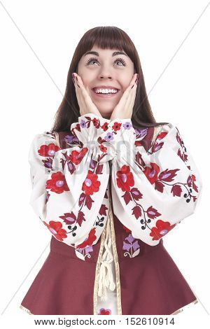 Natural Portrait of Caucasian Brunette Female Posing in National Flowery Dress. Showing Exclamation Touching Cheeks. Vertical Image Orientation
