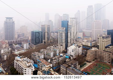NANJING CHINA - MARCH 18: Xinjiekou financial district in Nanjing on a foggy day. This is the downtown area of Nanjing where many banks and offices can be seen on March 18 2016 in Nanjing.