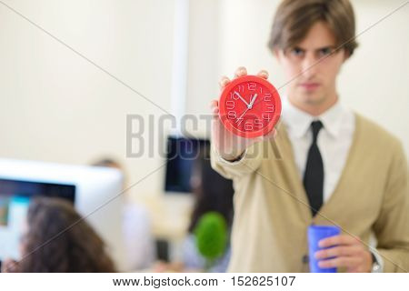 young angry businessman pointing his watch as concept of arrive late at the work at modern startup office