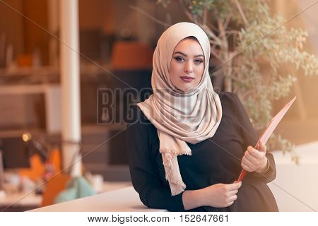 Arabian Business Woman Holding A Folder In Modern Startup Office