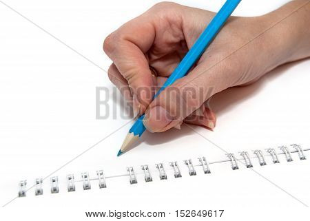 colored pencils in a female hand on noteboook