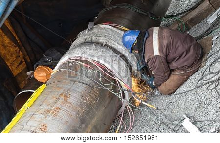 Trimming of the weld by mechanical means. Two locksmith carry out simultaneous machining of the weld with different sides
