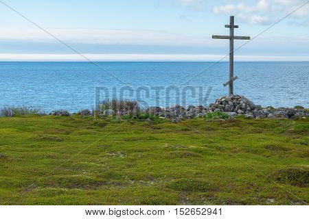 Wooden cross on the shores of the White Sea. Landscape religion history