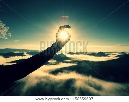 Man Hand Touch Sun. Misty Daybreak In A Beautiful Hills.