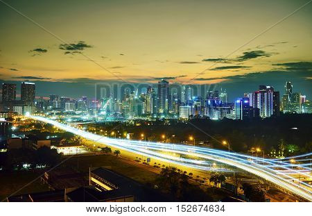 Abstract and car lighttrail background city skyline downtown background and highway interchanged nigh view .