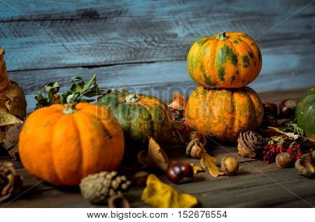 Autumn decorative pumpkins, fall leaves on a rustic wooden background, natural fall style decorations. Natural plenteous border background vintage mock up.
