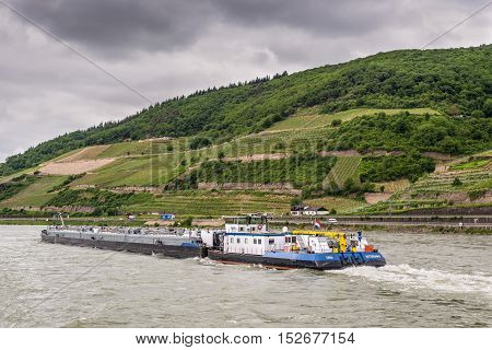 Trechtingshausen Germany - May 23 2016: Tanker barge (tank/gas) Thera on the Rhine River near Trechtingshausen in cloudy weather Rhine Valley UNESCO World Heritage Site Rhineland-Palatinate Germany.