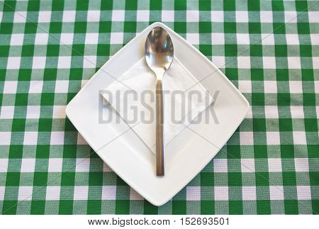 Empty Square Plate With Silver Spoon.