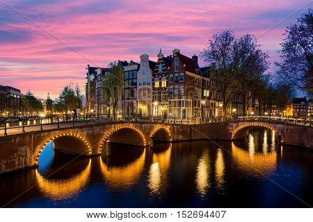Night city view in Amsterdam Netherlands. Canal and typical dutch houses at night in Amsterdam Netherlands