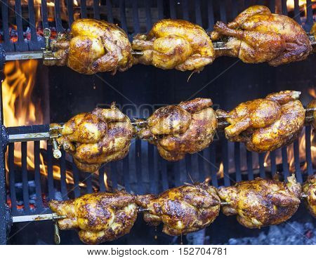 Chicken on a spit roasted by burning wood