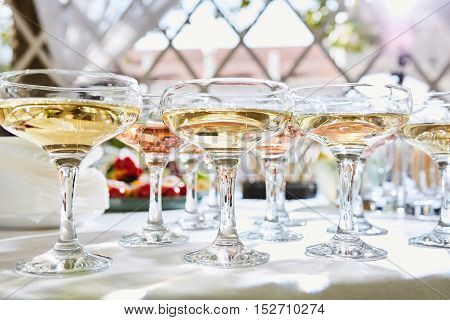 a row of glasses filled with champagne are lined up ready to be served