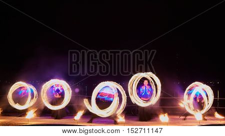 Artists juggling with burning poi's at fire performance. Long exposure causing painting with light.