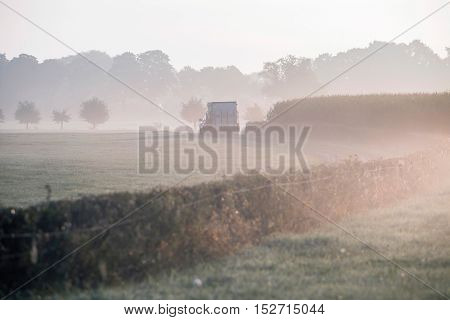 Car With Cattle Trailer Driving On Rural Dirt Road In Morning Mist. Geesteren. Gelderland. The Nethe