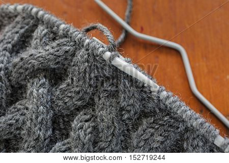 The process of knitting a hat with extensive cabling.