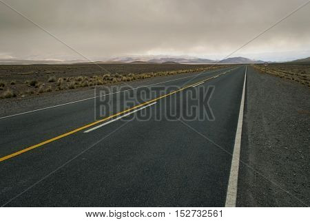 Spacious cloudy landscape crossed by empty road