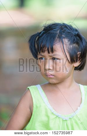 little asian girl with poder on her cheek look at right side.She dress in Thai local dress.Ragged.