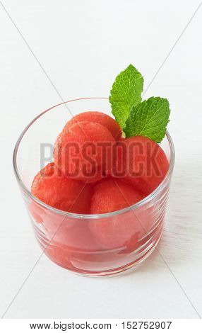 Healthy summer dessert. Watermelon balls with mint on white wooden table selective focus vertical