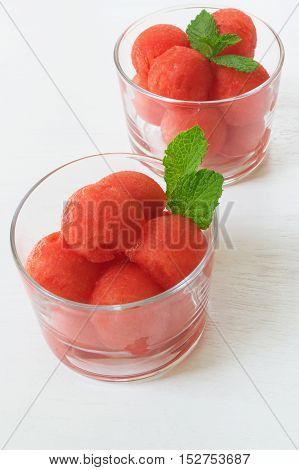 Healthy summer dessert. Watermelon balls with mint on white wooden table selective focus vertical