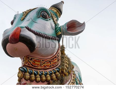 Madurai India - October 22 2013: In front of the Meenakshi temple in town stands this giant colorful statue of Nandi the bull. Close up of his head and neck only. Garlands of bells.