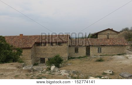 old stone farmhouse with outbuildings with tiled roof