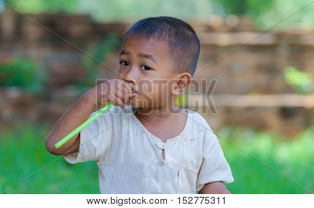 Asian boy with straw in mouthdirty with innocent play.
