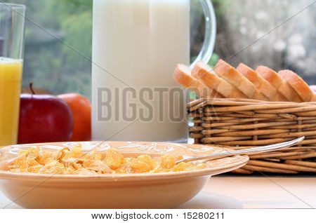 Copos de maíz y leche, jugo, fruta y pan de molde recién. Superficial de la profundidad de campo, se centran en el cor