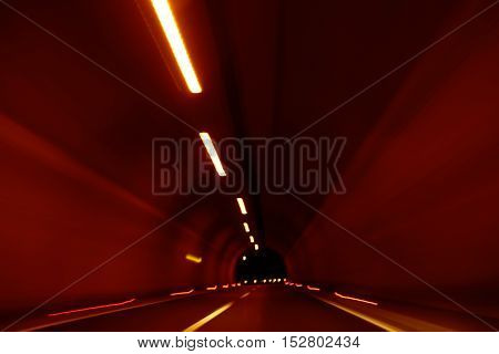 abstract blurred or defocused light motion on speed race in illuminated road tunnel yellow color as design flash background