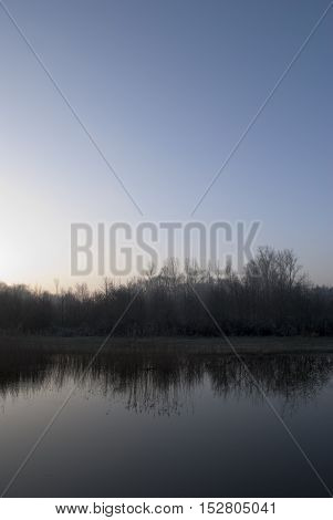 Sunrise over lake and frozen winter landscape