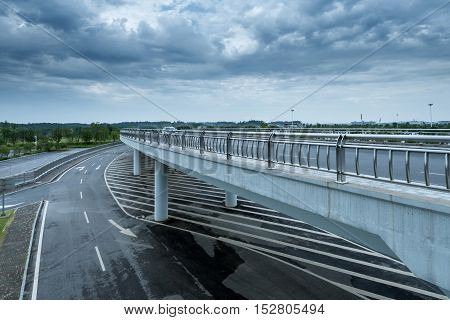 Dark clouds endless under the modern building highway.