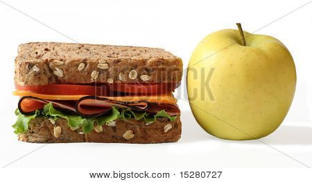 Schinken und Käse-Sandwich auf Vollkornbrot mit einem Apfel.