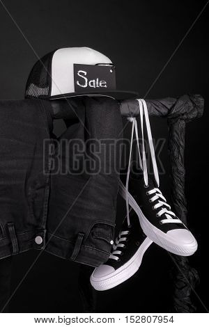 Sale Sign. Black And White Sneakers, Cap  Pant, Jeans Hanging On Clothes Rack   Background.   Friday