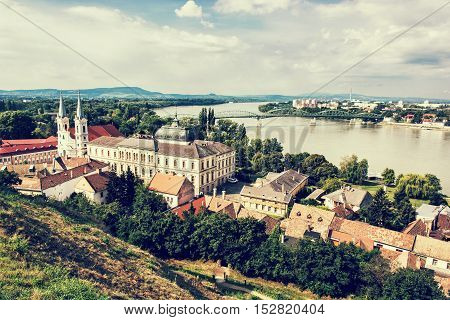 View from Esztergom basilica. Saint Ignatius church and Maria Valeria bridge Hungary. Travel destination. Cultural heritage. Retro photo filter. Religious architecture. Danube river.