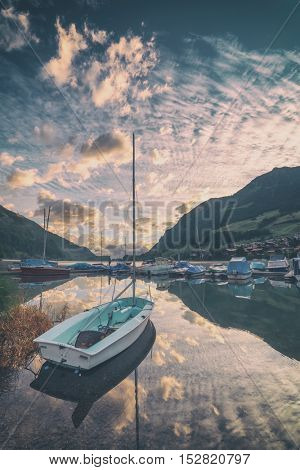 Amazing view of the Lungerersee lake with yachts in the morning mist. Lungern village, Switzerland, Europe, toned like Instagram filter