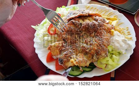 Chicken breast coated in batter and fries on a plate