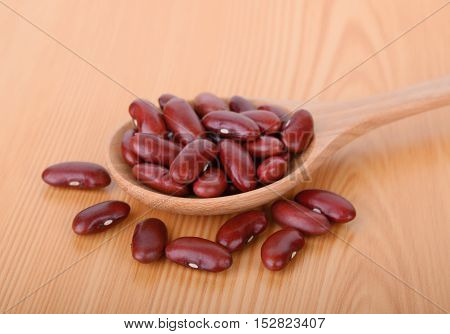 red bean in wood spoon on wood table