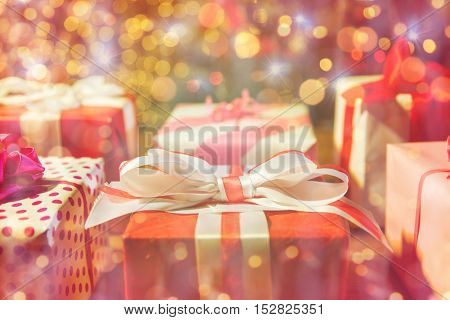 christmas, holidays, presents, new year and celebration concept - close up of gift boxes over christmas lights