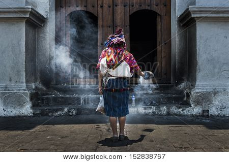 Chichicastenango Guatemala - April 26 2014: Mayan woman performing a ritual in front of the Santo Tomás church in the town of Chichicastenango in Guatemala