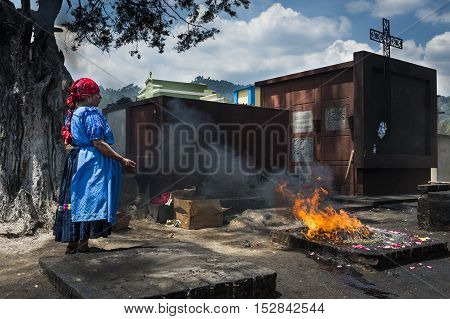 Chichicastenango Guatemala - April 24 2014: Maya woman performing a traditional mayan ritual in the cemetery of the town of Chichicastenango in Guatemala