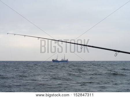 fishing rod with spinning-wheel on sea background